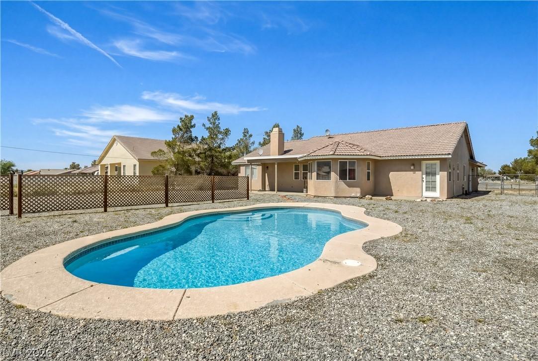 Image 1: View of swimming pool with a fenced backyard and p