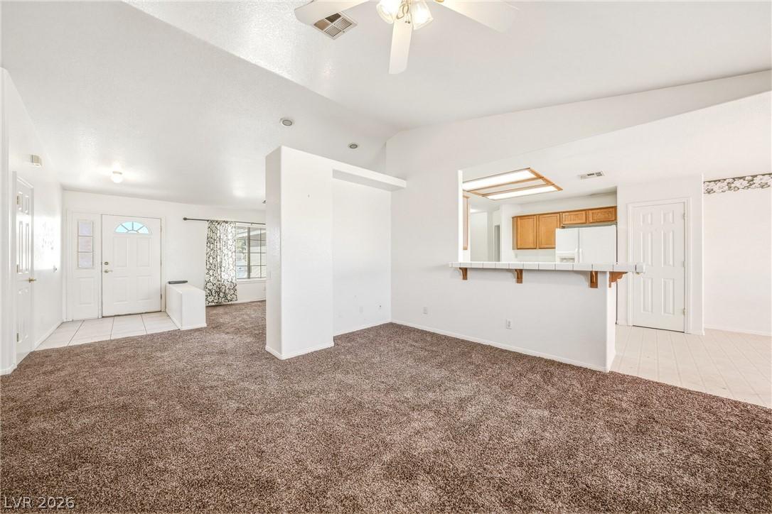 Image 4: A spacious living room featuring soft carpet, a ve