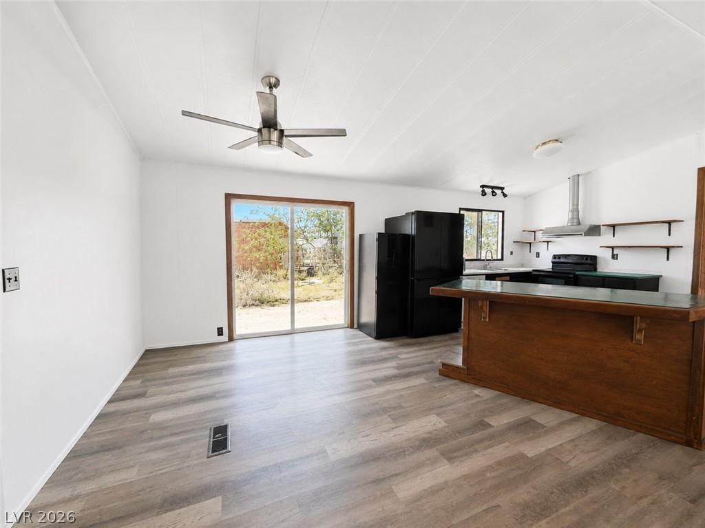 Image 4: A combined living and kitchen area features wood-l