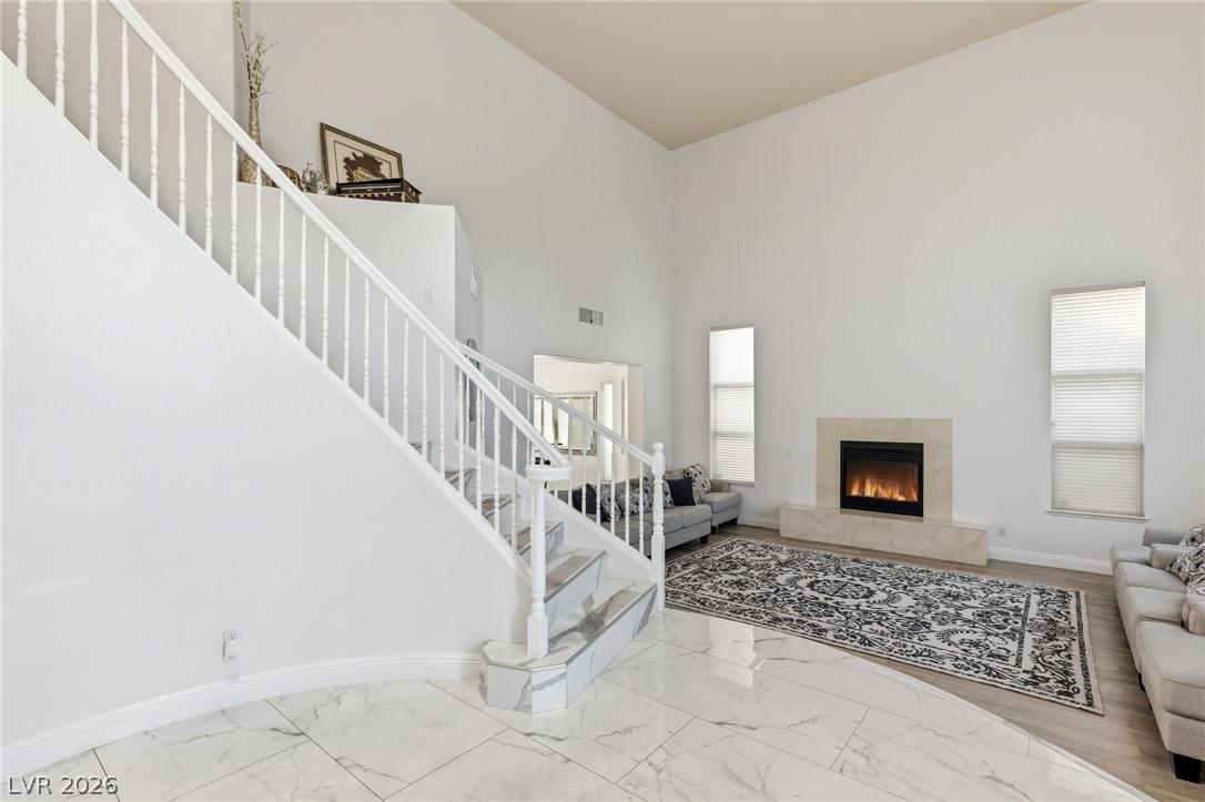 Image 4: A grand staircase and a cozy fireplace create an i