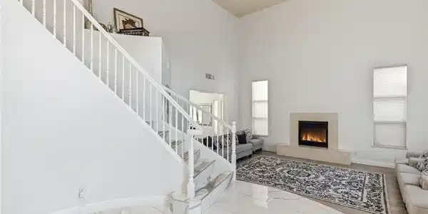 Image 4: A grand staircase and a cozy fireplace create an i