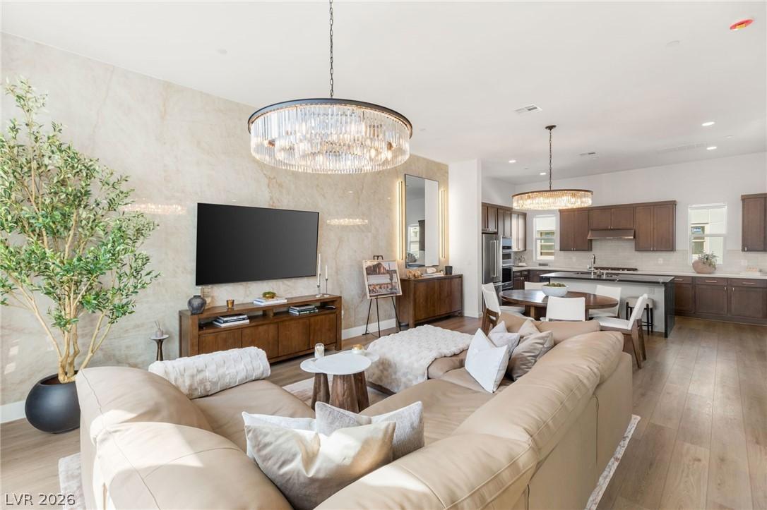 Image 1: Living room featuring hanging lights and light woo