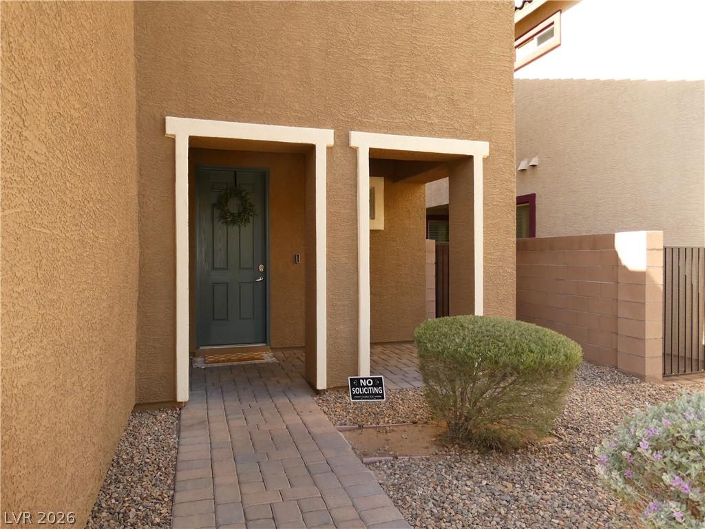 Image 2: A welcoming front entry features a paved pathway l