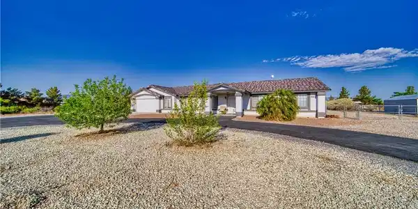 Image 2: A well-maintained single-story home with a paved d
