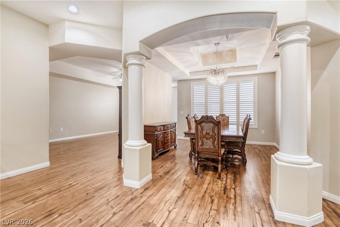 Image 2: This inviting dining area features warm wood floor