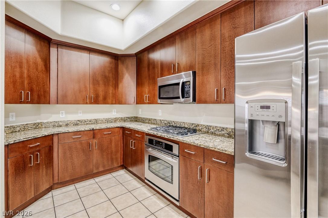 Image 4: This kitchen features rich wood cabinetry and ampl