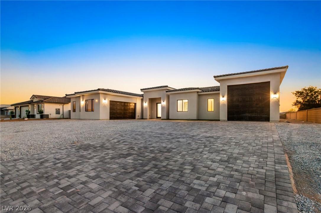 Image 2: Modern desert home showcases a vast paver driveway