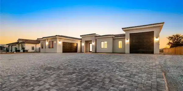 Image 2: Modern desert home showcases a vast paver driveway