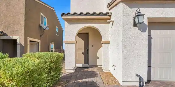 Image 4: Arched front door welcomes you from a charming pav