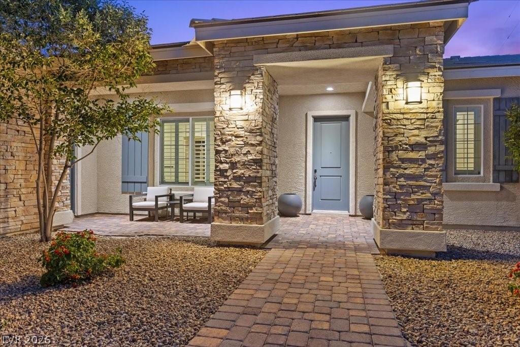 Image 4: An inviting entry with stone accents and a paver p