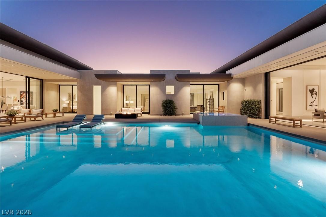Image 2: This modern oasis features an expansive pool, perf