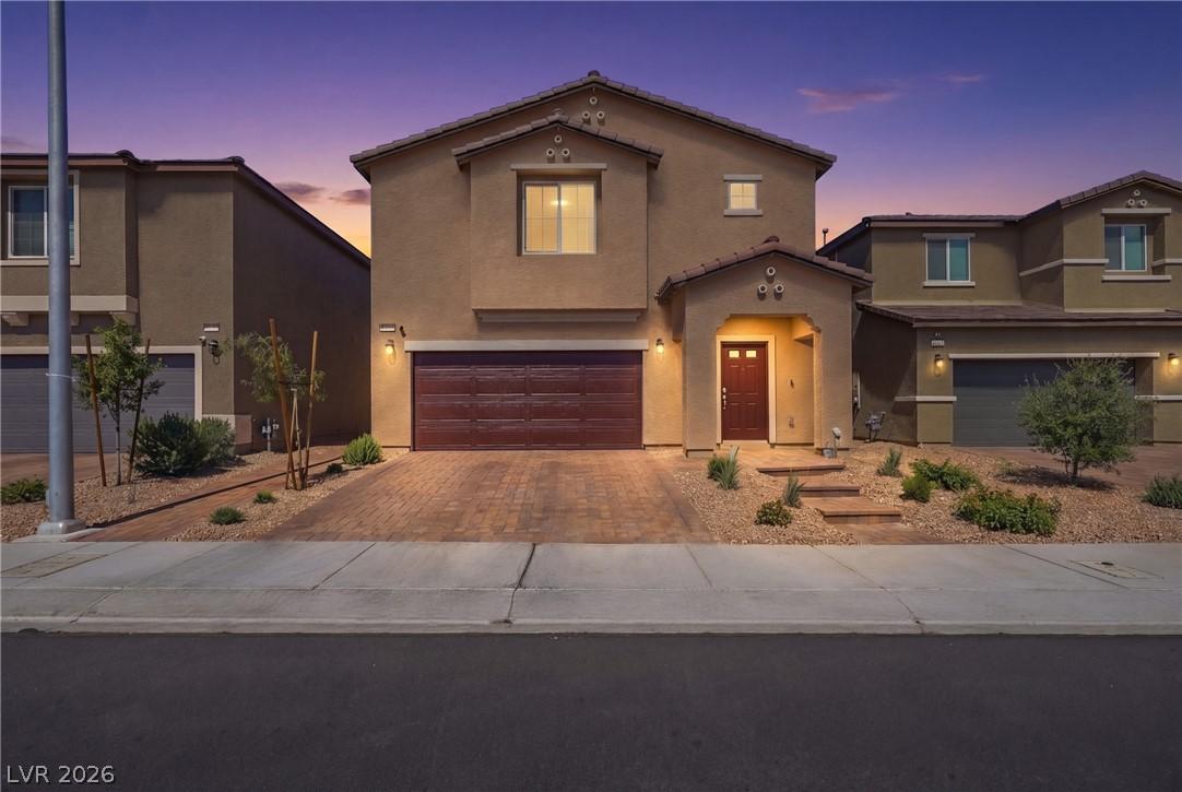 Image 1: A welcoming front entry, a paver driveway and dese