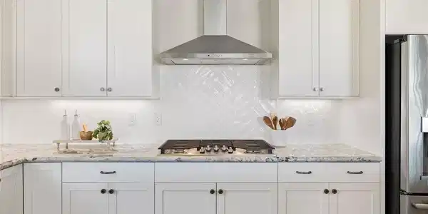 Image 4: Gleaming stone countertops and a modern range hood
