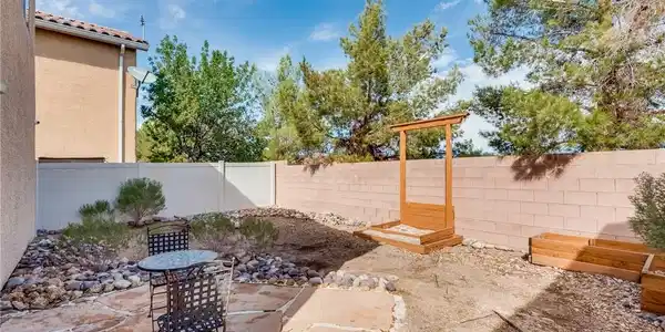 Image 4: An inviting stone patio opens to a walled backyard