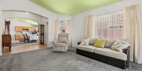 Image 2: An open arched doorway connects the plushly carpet