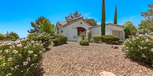 Image 2: A charming stucco residence with a red tile roof a