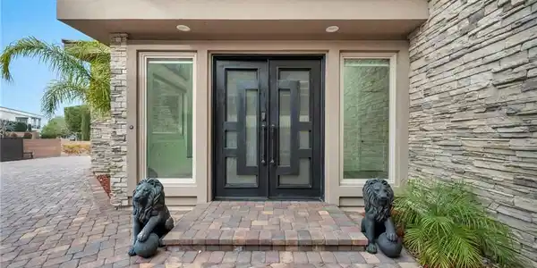 Image 2: Doorway to property featuring stone siding, stucco