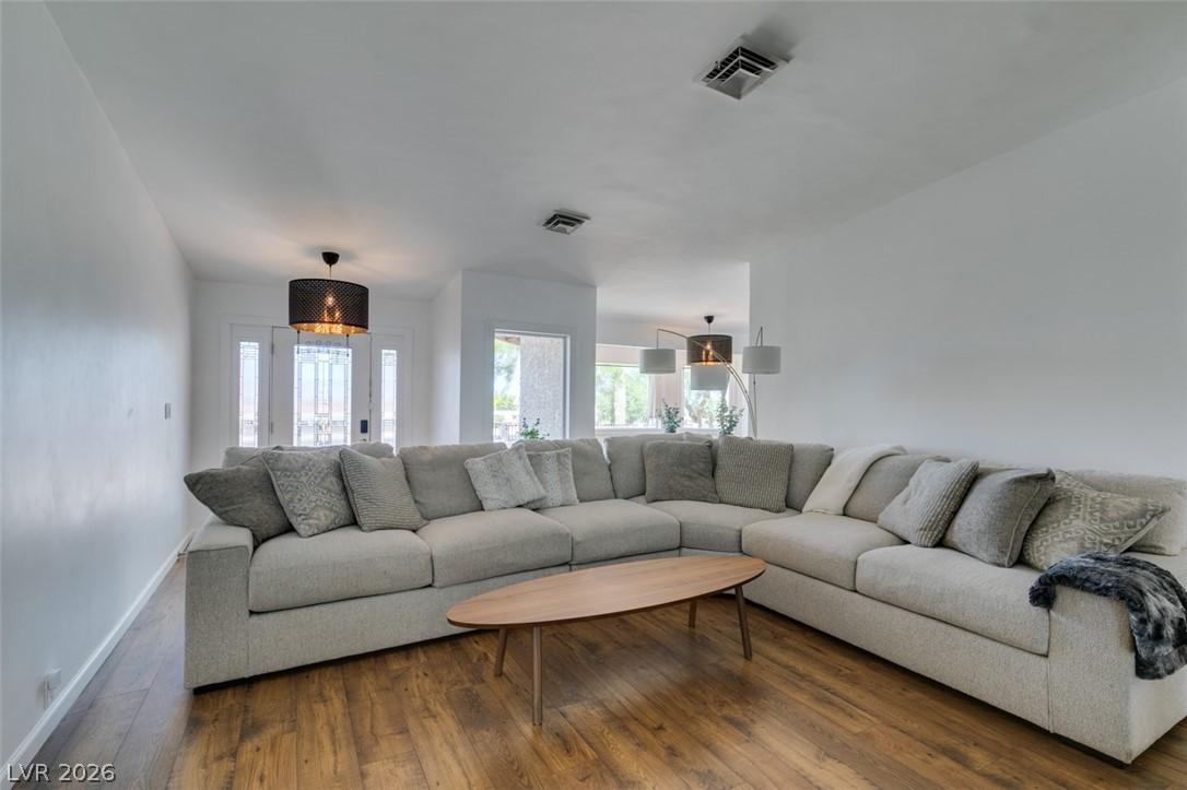 Image 4: This bright living area features wood flooring, cr