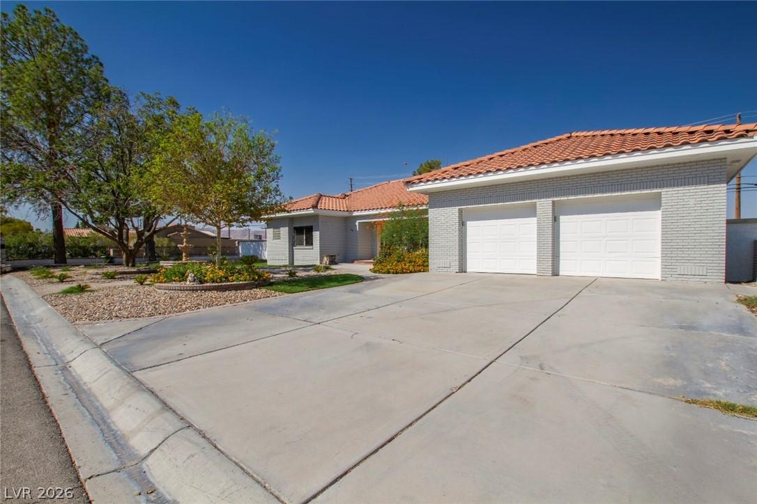 Image 2: This residence features a broad concrete driveway