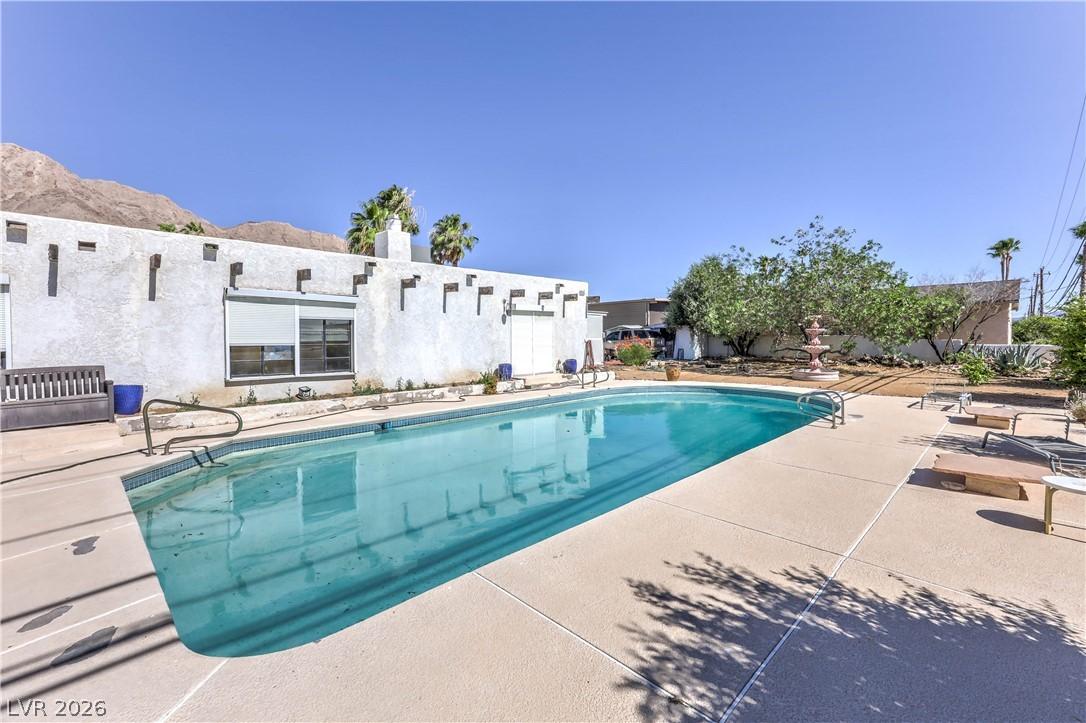Image 3: An inviting backyard oasis features a glistening p