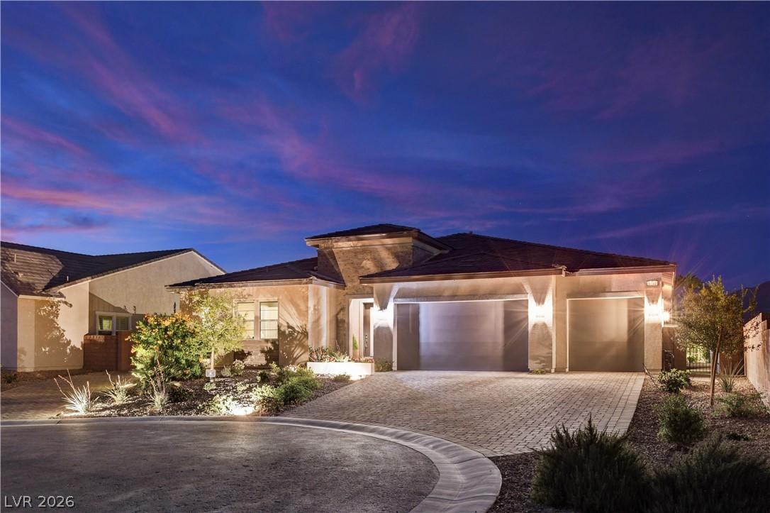 Image 1: Illuminated by dusk, this home presents a stately