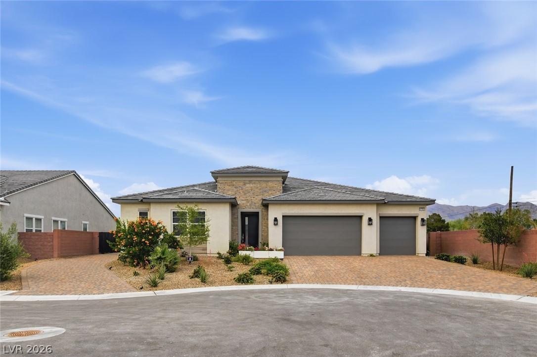 Image 4: This newly built home features a brick driveway, a