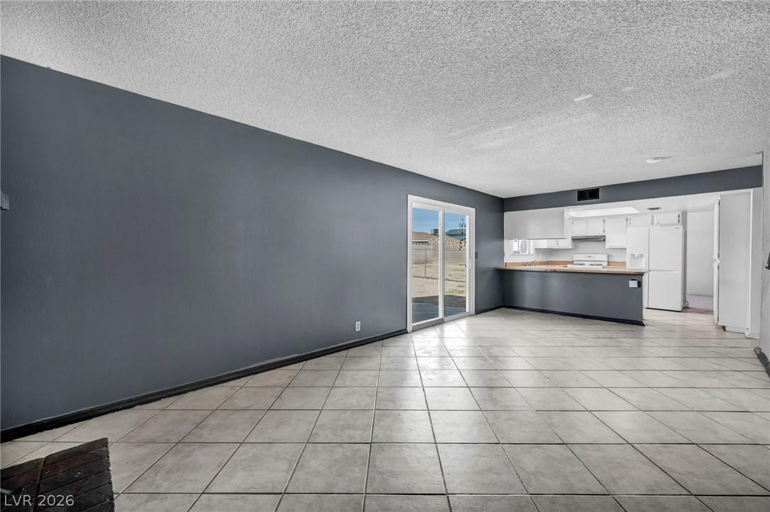 Image 3: This bright, open living area features a kitchen w