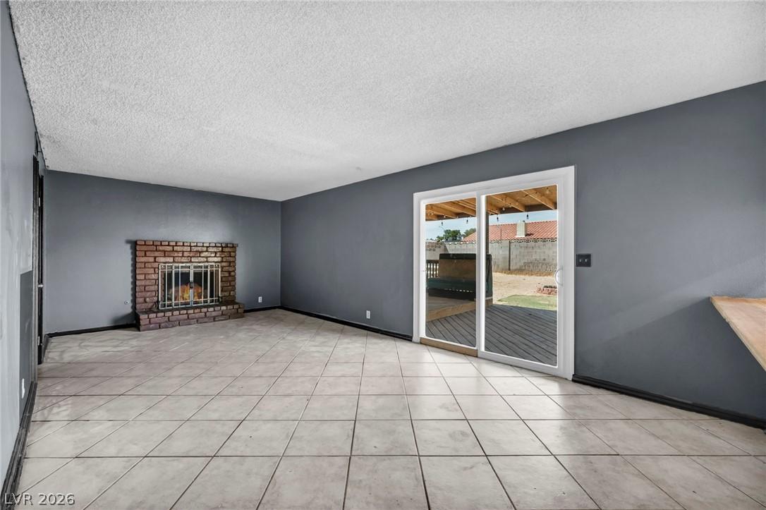 Image 4: This living area features a classic brick fireplac