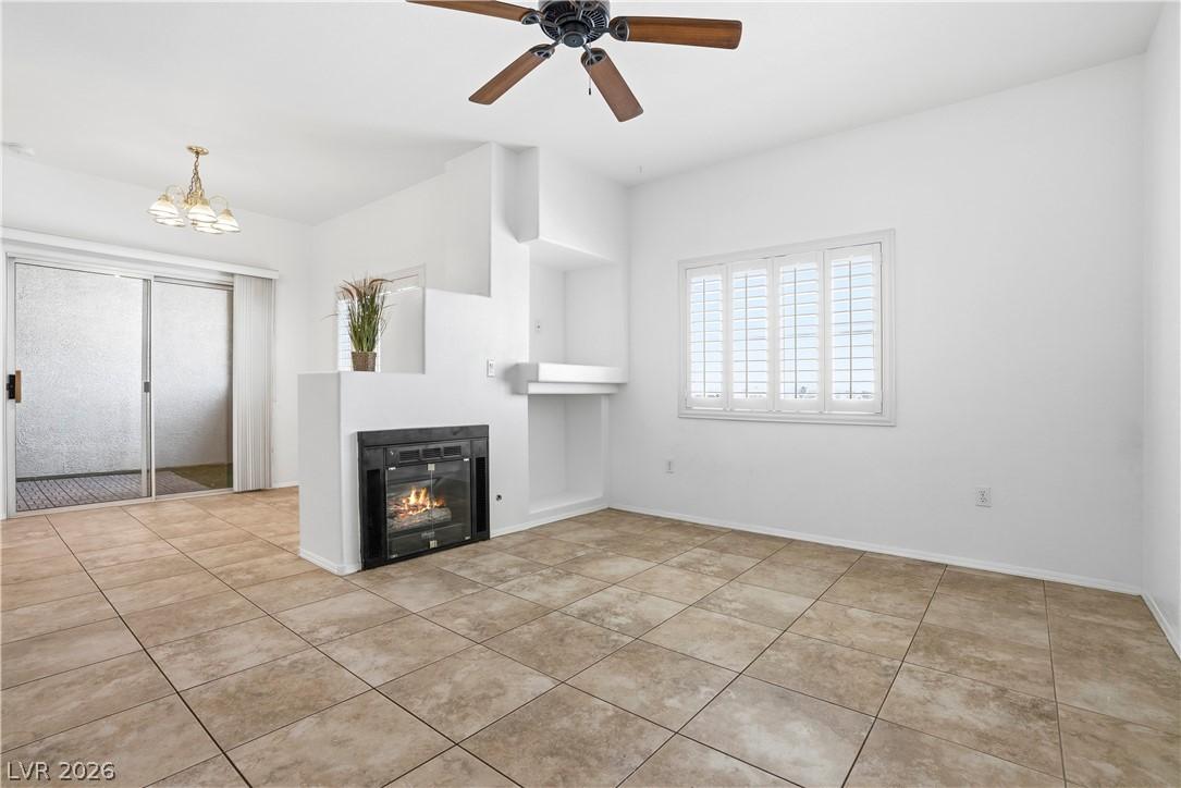 Image 2: This living space features a cozy fireplace, tiled