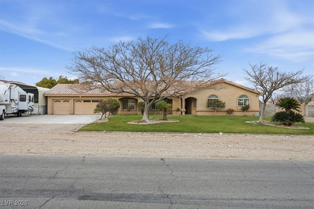 Image 2: View of front of home with a front yard, stucco si