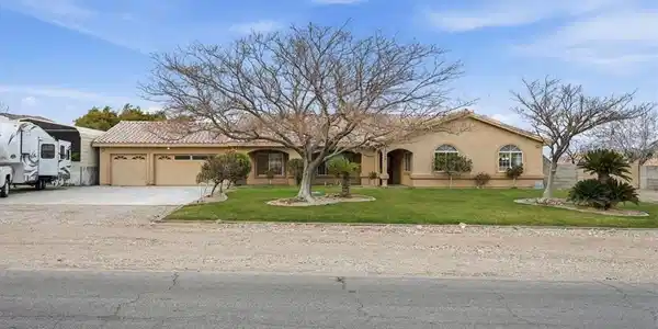 Image 2: View of front of home with a front yard, stucco si