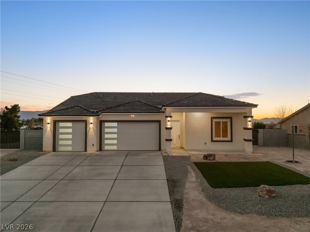 Image 1: View of front of home with an attached garage, a t