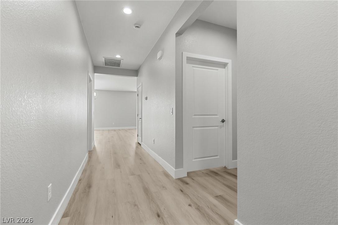 Image 2: Corridor with a textured wall, light wood-type flo