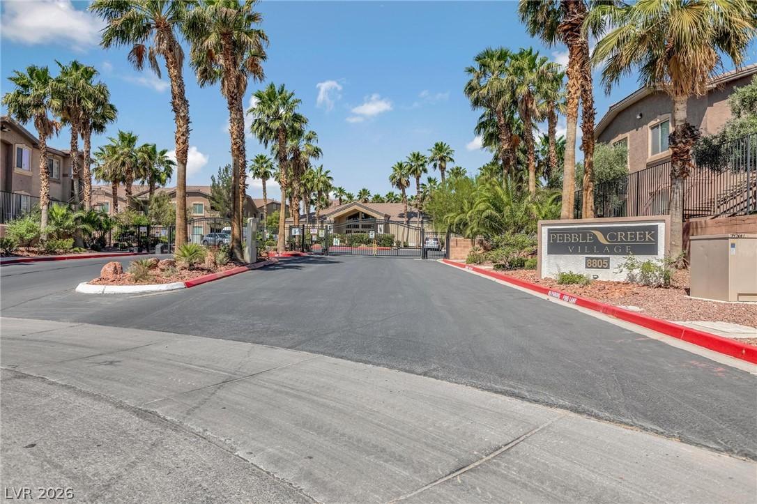 Image 1: This gated community entrance features lush palm t