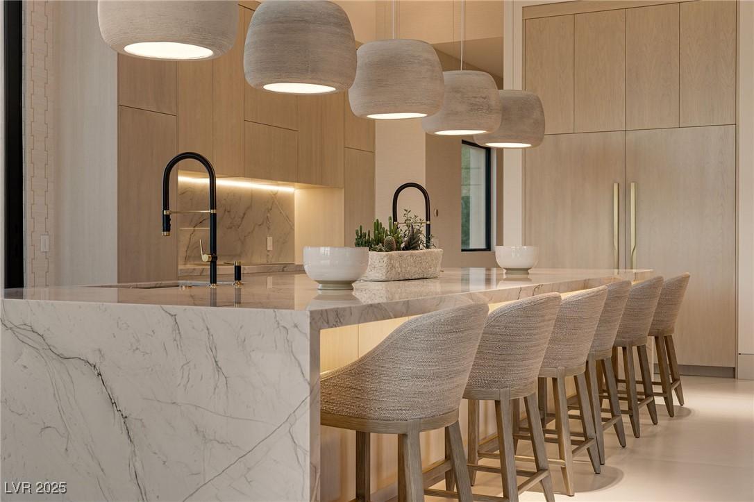 Image 4: Bar area with modern cabinets, light stone counter