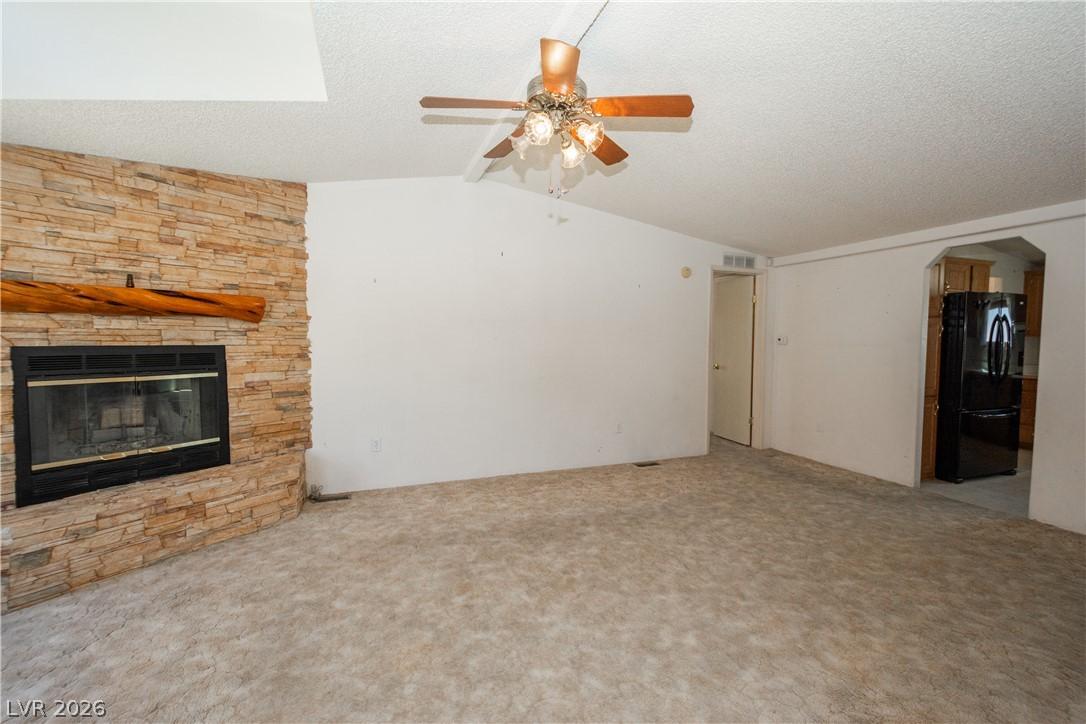 Image 2: A cozy living space features a corner fireplace wi