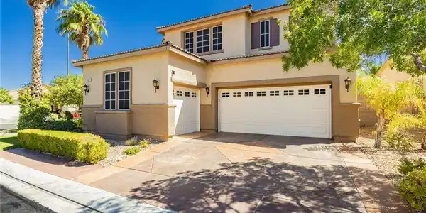 Image 2: A well-maintained stucco home with a two-car garag