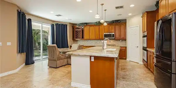 Image 3: A chef's kitchen features granite countertops, a c