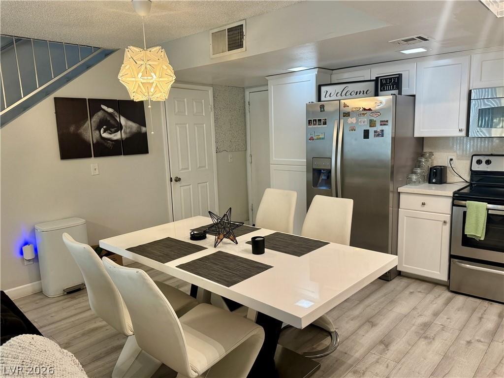 Image 2: Dining area featuring light wood finished floors a