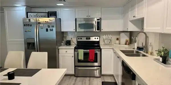 Image 4: Kitchen with stainless steel appliances, a sink, l
