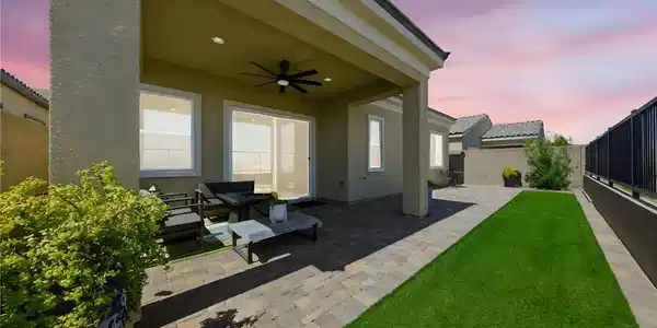 Image 3: A well-lit covered patio and paved yard offer an i