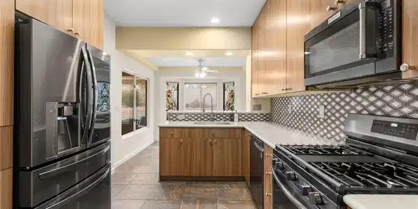 Image 3: Natural wood cabinetry pairs with modern stainless
