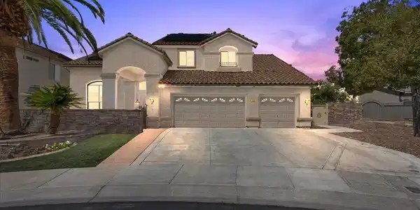 Image 2: A spacious driveway leads to this classic stucco r