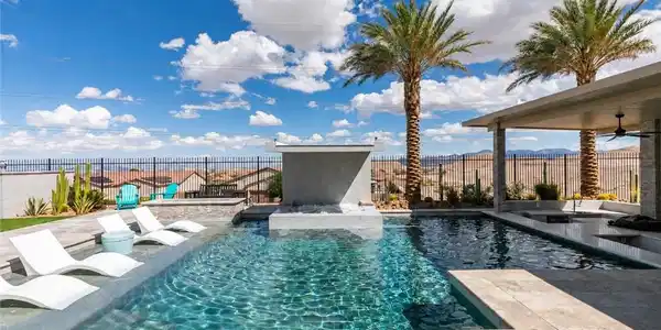 Image 4: An inviting backyard oasis centers around a sparkl