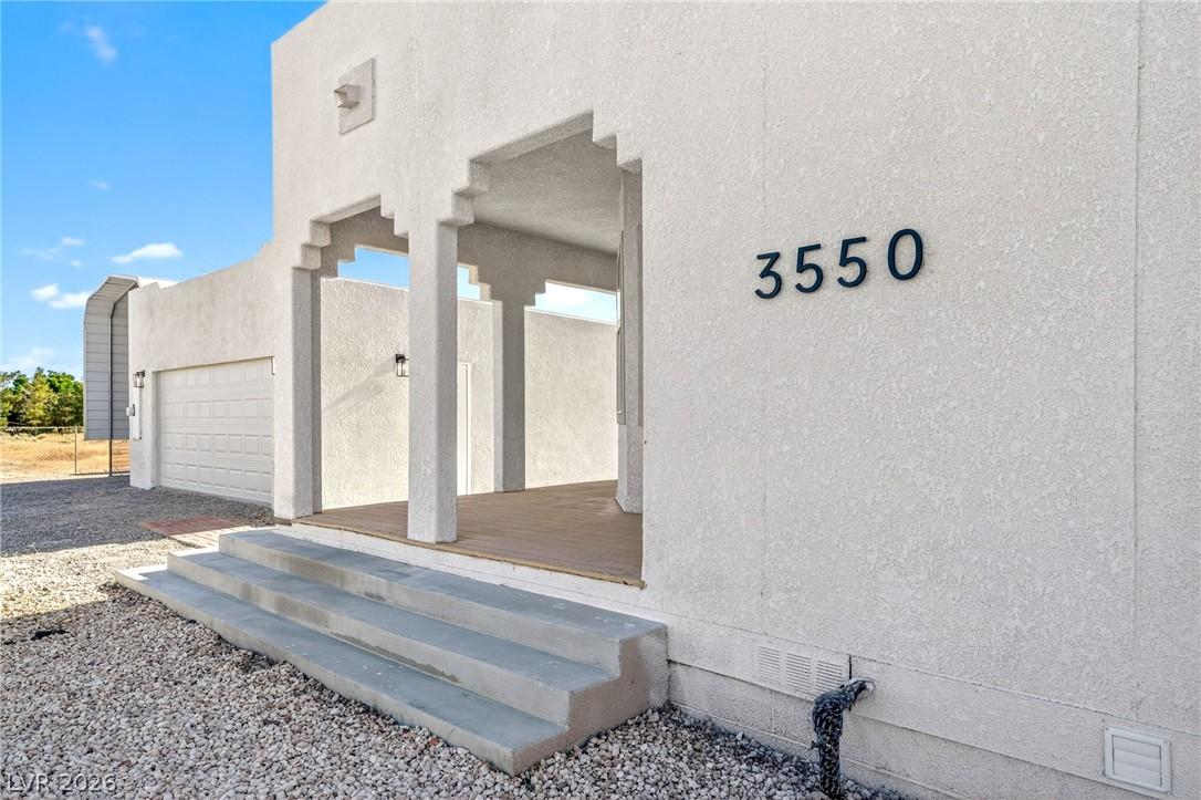 Image 2: A striking exterior presents a clean stucco finish