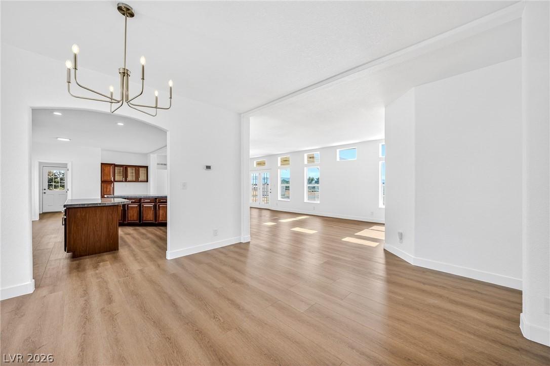 Image 3: Luminous interior with rich wood flooring and ampl