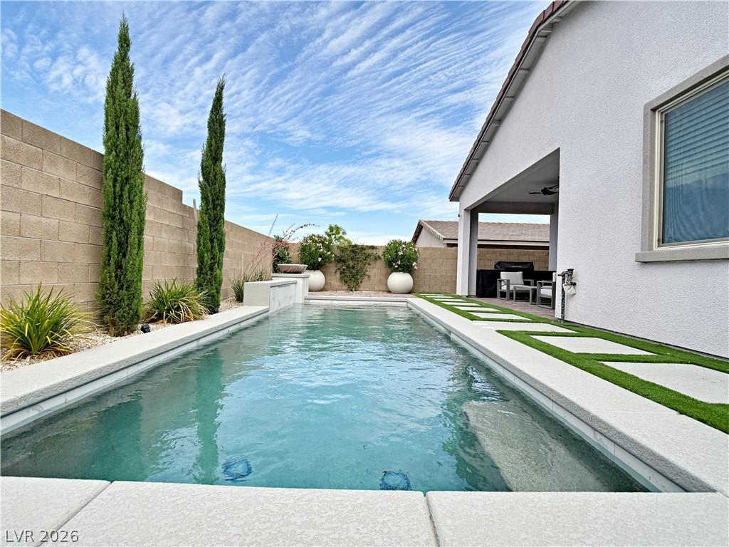 Image 2: An inviting backyard oasis features a sparkling po