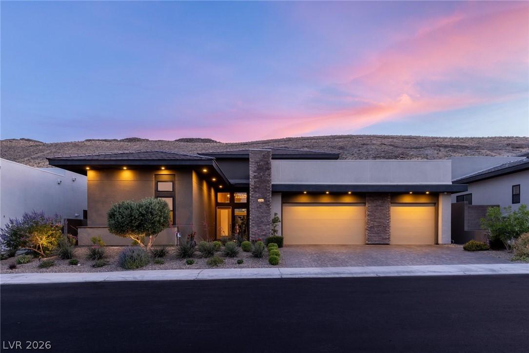 Image 2: Dramatic sunset over this modern home, featuring a