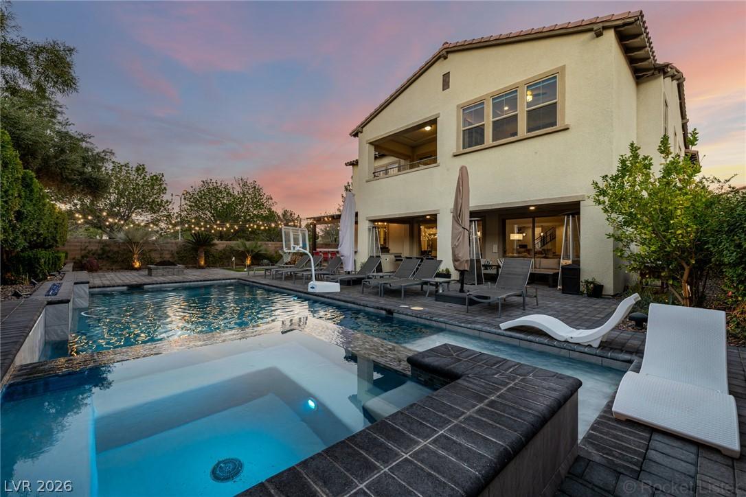 Image 2: A spacious backyard oasis features a shimmering po