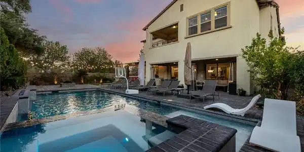 Image 2: A spacious backyard oasis features a shimmering po